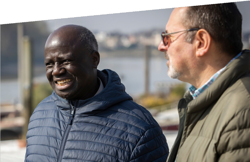 Photograph of two men talking.