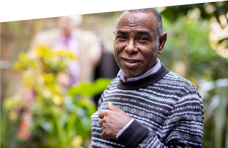 Photograph of a man walking in his garden.